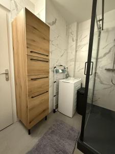 a bathroom with a wooden cabinet next to a toilet at T3 Rénové vue mer in Saint-Jean-de-Monts +12 photos