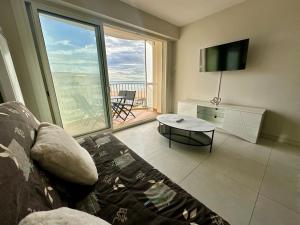 a living room with a couch and a large window at T3 Rénové vue mer in Saint-Jean-de-Monts