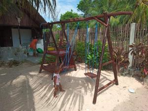 a small child standing in front of a swing at Ravoravo Beachfront Family lodge in Lokobe National Park-Nosy be, autentic Madagascar expiriance with europian confort in Antafondro