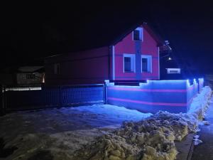 a house is lit up in the snow at night at Kuća NADA in Donja Voća