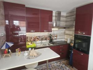a kitchen with purple cabinets and a sink at Kuća NADA in Donja Voća +4 photos