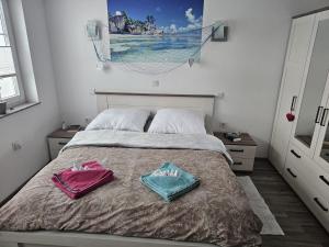 a bedroom with a bed with two towels on it at Kuća NADA in Donja Voća