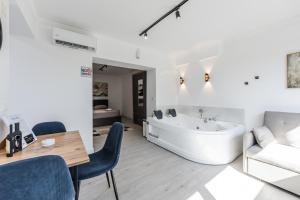 a bathroom with a tub and a table and chairs at Green Luxe Suite 2 by PikHost in Shkodër