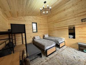 a log cabin with two beds and a flat screen tv at Han Karakol in Karakol