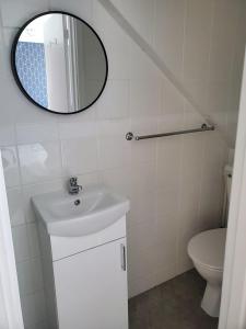 a bathroom with a sink and a mirror and a toilet at Beachside 1 in Saint Helier Jersey +10 photos