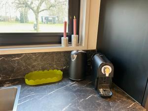 a kitchen counter with a toaster and a phone on it at Tiny House 'Het Chalet' in Berlicum