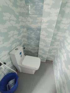 a small bathroom with a toilet and a trash can at Devagram Guest house in Dergaon