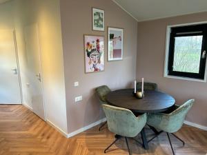 a dining room with a wooden table and chairs at Tiny House 'Het Chalet' in Berlicum +5 photos