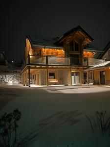 a house at night with the lights on at Ferienwohnung Uplandblockhaus in Willingen