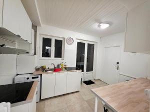 a kitchen with white cabinets and a table in it at Chambre 1 in Toulouse