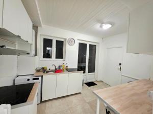 a kitchen with white cabinets and a table in it at Chambre 1 in Toulouse