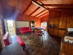 a living room with a red couch and a table at Backpackers at Kanaan in Hazyview