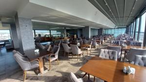 a dining room with tables and chairs and windows at Margi Hotel in Edirne