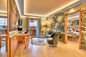 a living room with a bedroom and a bed at Panoramahotel Grobauer in Spiegelau