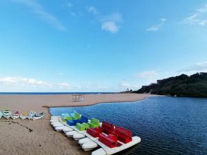 a row of colorful boats on a beach at Boathouse Bed & Biscuit - Lower Deck in Margate