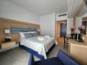 a hotel room with a bed and a table and chairs at Paradise Resort Evia, a member of Radisson Individuals in Eretria +32 photos
