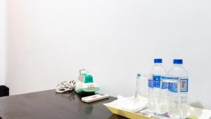 a table with bottles of water and controllers on it at Pearl Guest House in Dambulla