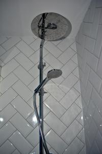 a shower with a shower head in a bathroom at The Ugly Duckling in Telford