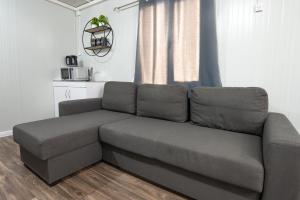 a couch sitting in a living room next to a window at אגם בגליל -וילה ו-3 סוויטות מקסימות למשפחות עם בריכה מחוממת in Wadi Keren +64 photos