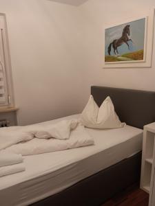 a bed with a picture of a horse on the wall at Ferienhaus by Rossano Boutique Hotel & Ristorante in Ansbach