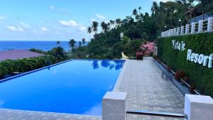 a large blue swimming pool next to the ocean at Mata Ie Resort in Sabang