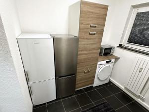 a small kitchen with a refrigerator and a washing machine at Apartment in Bergkamen in Bergkamen +3 photos