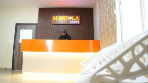 a man sitting at a counter in front of a mirror at Mandola Stays in Girgaon