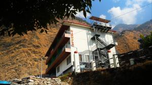 a building on a hill with a mountain in the background at Mandola Stays in Girgaon
