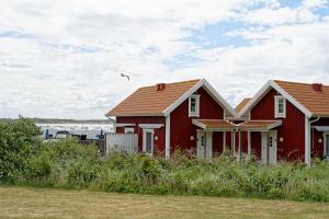 two red houses with a bird flying above them at Apelvikens Camping & Cottages in Varberg