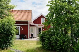 a red house with a person in a wheelchair outside at Apelvikens Camping & Cottages in Varberg