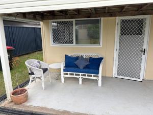 a porch with a blue couch and two chairs at Family Friendly One Bedroom Studio in Brisbane