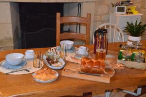 a wooden table with bread and pastries on it at Chambre Pantagruel Le dolmen in Thizay