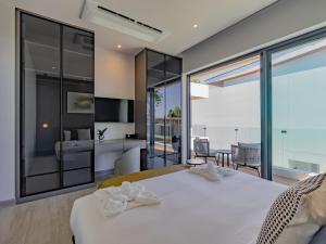 a bedroom with a white bed and a large window at Dara Villas - Rawai in Rawai Beach +129 photos