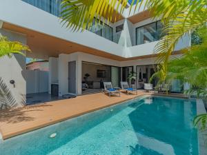 a villa with a swimming pool and a house at Dara Villas - Rawai in Rawai Beach