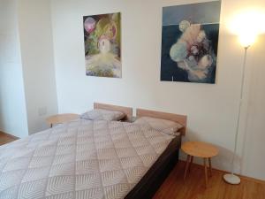 a bedroom with a bed and two paintings on the wall at Apartments Košević in Osijek