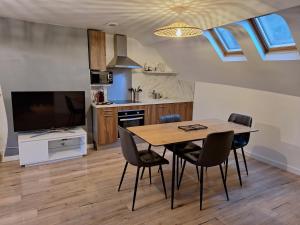 a kitchen and dining room with a table and chairs at Faubourg des voyageurs 7 - T2 climatisé 4 personnes - proche axe autoroute et gare in Saran
