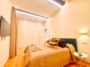 a bedroom with a bed and a chair and a table at Amazing San Lorenzo 19 Apt with Private Parking in Genoa