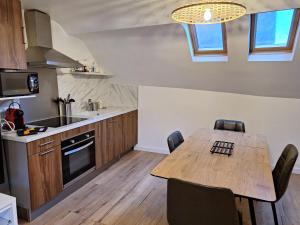 a kitchen with a wooden table and a dining room at Faubourg des voyageurs 7 - T2 climatisé 4 personnes - proche axe autoroute et gare in Saran +7 photos