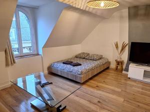 a bedroom with a bed and a tv and a glass table at Faubourg des voyageurs 7 - T2 climatisé 4 personnes - proche axe autoroute et gare in Saran