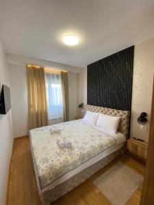 a bedroom with a large bed with two shoes on it at Apartman Tornik Relax&Spa 3 in Zlatibor +13 photos