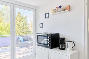 a microwave sitting on a cabinet in a room with a window at Ferienwohnung Trave Ufer Moba-Travel in Lübeck