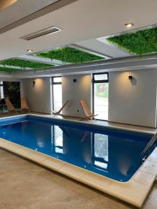 a large swimming pool with chairs in a building at Apartman Tornik Relax&Spa 3 in Zlatibor