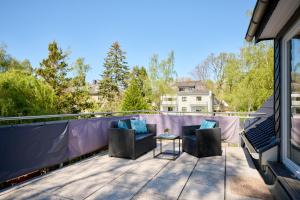 a patio with two chairs and a table on a balcony at Ferienwohnung Trave Ufer Moba-Travel in Lübeck +8 photos