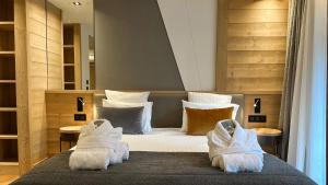 a bedroom with a bed with towels on it at MGM Hôtels & Résidences - Hôtel Akoya in Valmorel +24 photos