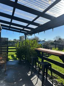 a picnic table and stools under a pergola at The Shed in Cambridge