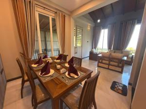 a dining room with a table and chairs and a living room at Sunrise Villa in Kandy