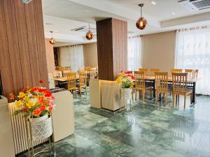 a dining room with tables and chairs and flowers in vases at โรงแรมสวนดุสิต เพลส in Ban Nong Chaeng