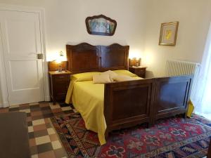 a bedroom with a large wooden bed with yellow sheets at Se mi vuoi lasciare in Carcare