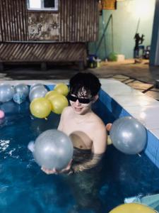 a man in a pool with balls in the water at Shigemary Kubohouse in Capepisa