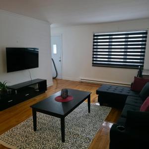a living room with a couch and a coffee table at Appartement cosy, comme à la maison in Montreal